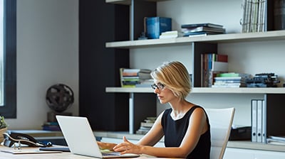 Woman seated at desk working with laptop