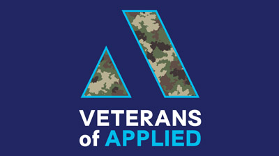 The Applied Systems logo filled in with camouflage print on a dark blue background with the words "Veterans of Applied" below it.
