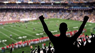 Silhouette of an excited sports fan at a football game
