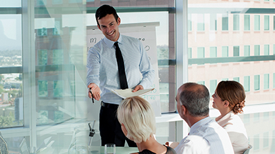 A businessman presenting to three people