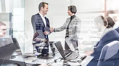 Business meeting and reflection of people working on laptops