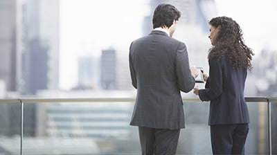 Two business people looking at a tablet on a rooftop